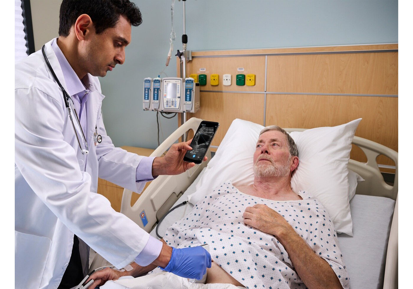 Clinician scanning a patient at the bedside with the Vscan Air wireless ultrasound