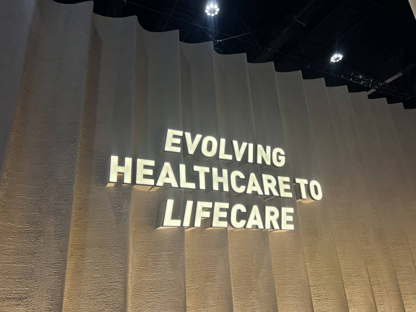 Illuminated sign reading "Evolving Healthcare to Lifecare" on an exhibition stand at the Future Health Summit 2026, ADNEC Centre Abu Dhabi