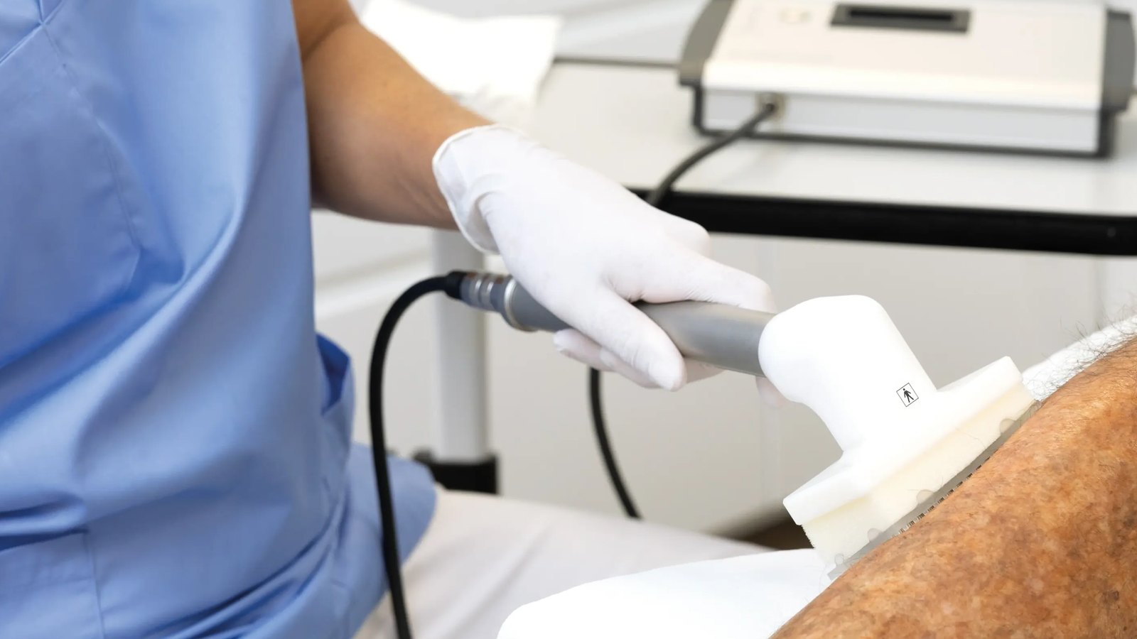 جهاز العلاج بالبلازما الباردة للجروح CINOGY PlasmaDerm Universal 3 يد طبيب بقفاز تثبّت قبضة PlasmaDerm Flex وفاصلها على أسفل ساق المريض