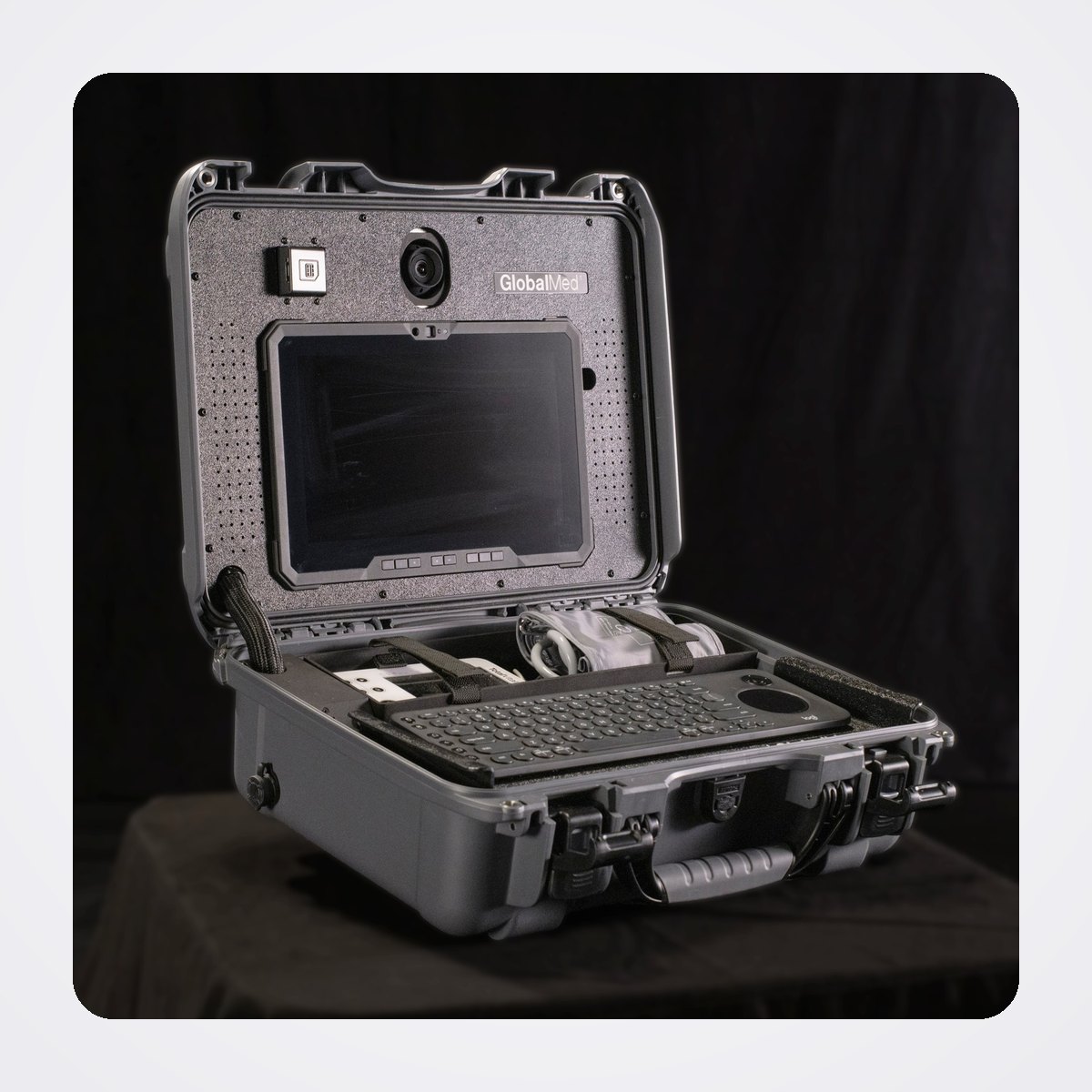 محطة الفحص المتنقلة GlobalMed Transportable Exam Station (TES) مع كاميرا TotalExam للطب عن بُعد 1 محطة الفحص المتنقلة من GlobalMed مفتوحة، يظهر فيها الجهاز اللوحي المتين والكاميرا ولوحة المفاتيح داخل حقيبة رمادية بعجلات