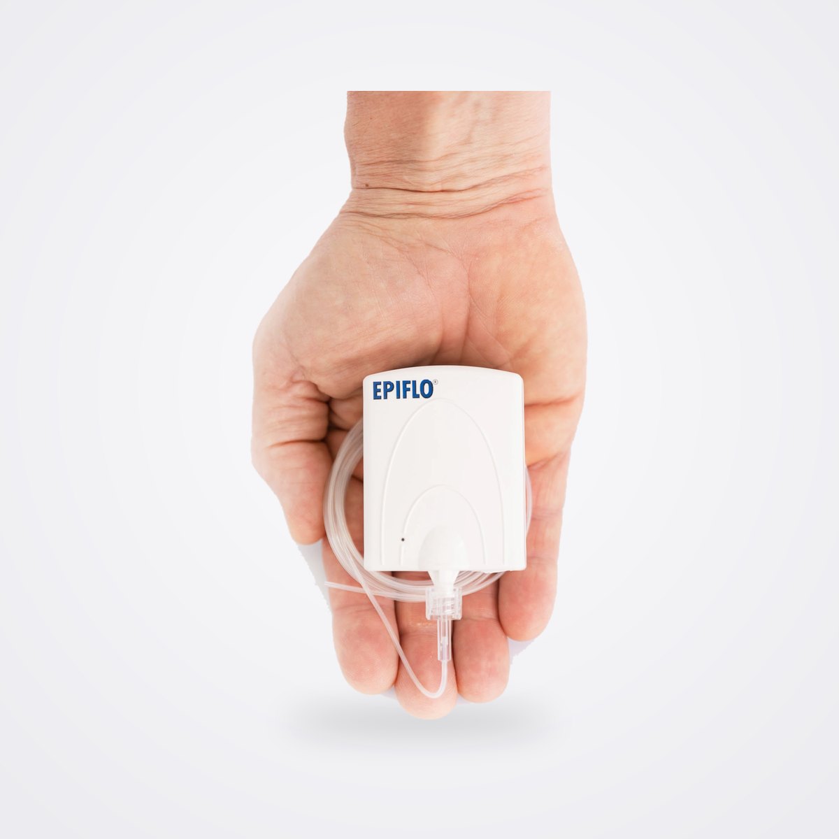 جهاز EPIFLO-28 من Ogenix للعلاج المستمر بالأكسجين عبر الجلد 1 مكثف أكسجين EPIFLO أبيض بحجم الكف في يد مفتوحة، موصول به أنبوب الأكسجين الشفاف