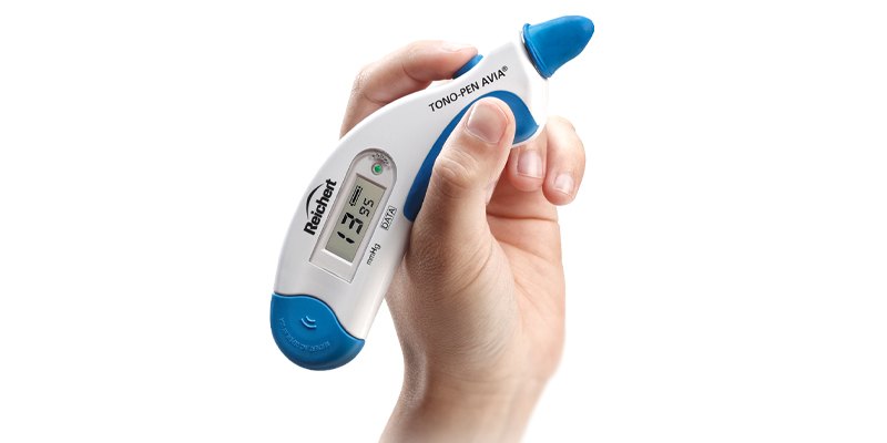 مقياس ضغط العين بالتسطيح المحمول باليد Reichert Tono-Pen AVIA بنمط Quick-Tap 3 مقياس ضغط العين المحمول Tono-Pen AVIA في يد واحدة وطرفه إلى الأعلى، على خلفية بيضاء
