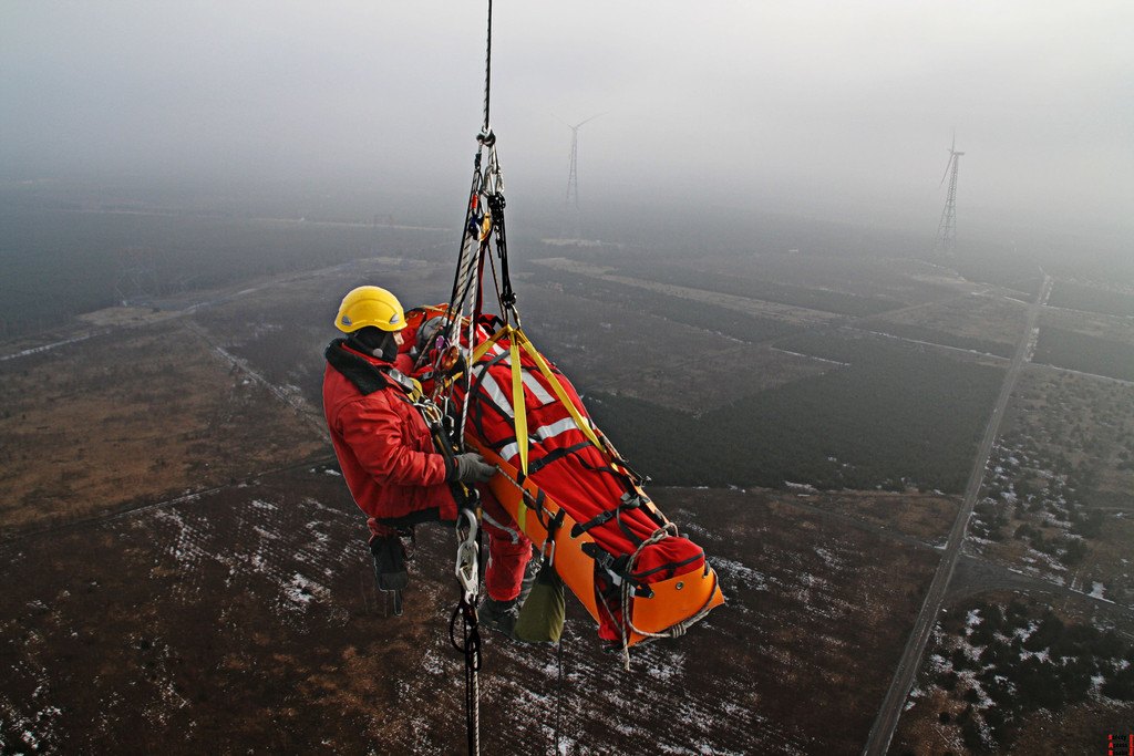 Skedco Sked Basic Rescue System Roll-Up Rescue Stretcher 3 Rescuer hoisted with a patient packaged in an orange Sked stretcher at height