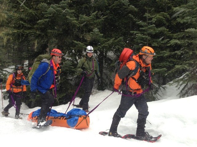 Skedco Sked Basic Rescue System Roll-Up Rescue Stretcher 5 Rescue team hauling a patient in a Sked stretcher across snow
