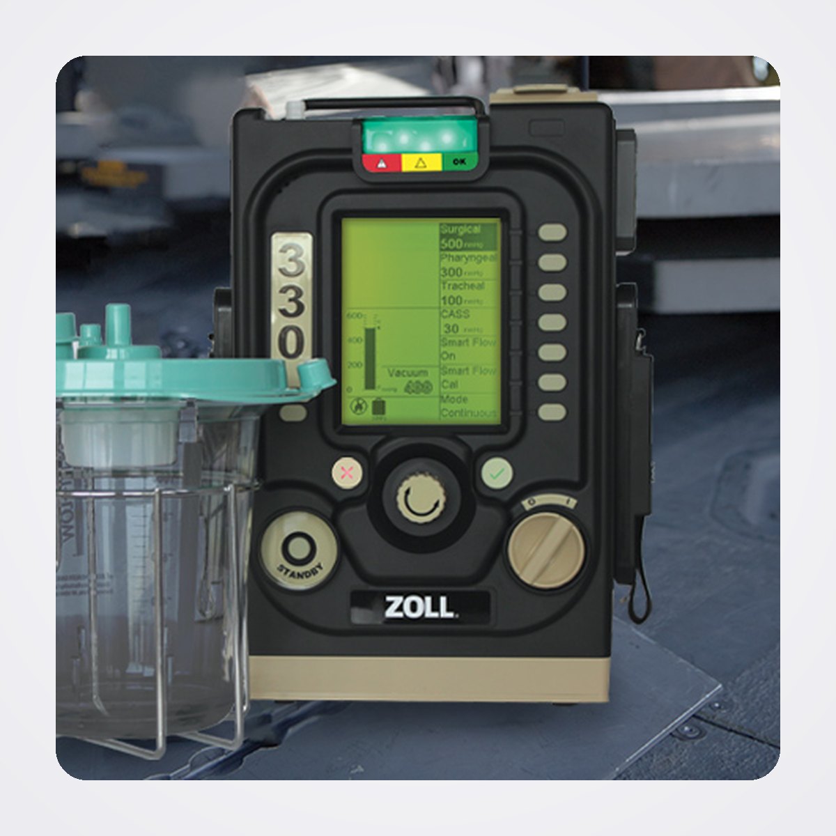جهاز الشفط المحمول متعدد الوظائف ZOLL 330 Multifunction Aspirator 1 جهاز ZOLL 330 Multifunction Aspirator مع وعاء التجميع في حامله، على أرضية طائرة